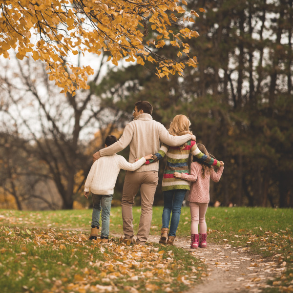 A son, father, wife, and daughter walking in Autumn