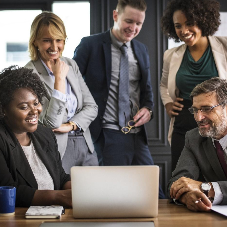 5 people in a meeting looking at a laptop